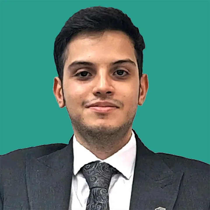 MohamadAli Hasan Ghorban Photo in a dark grey suit and tie with a teal green background