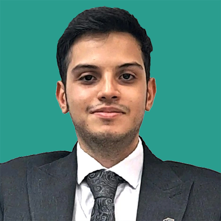 MohamadAli Hasan Ghorban Photo in a dark grey suit and tie with a teal green background