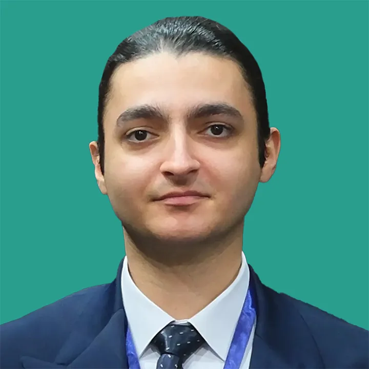 Mahdiyar Baladzadeh Photo in a dark blue suit and tie with a teal green background