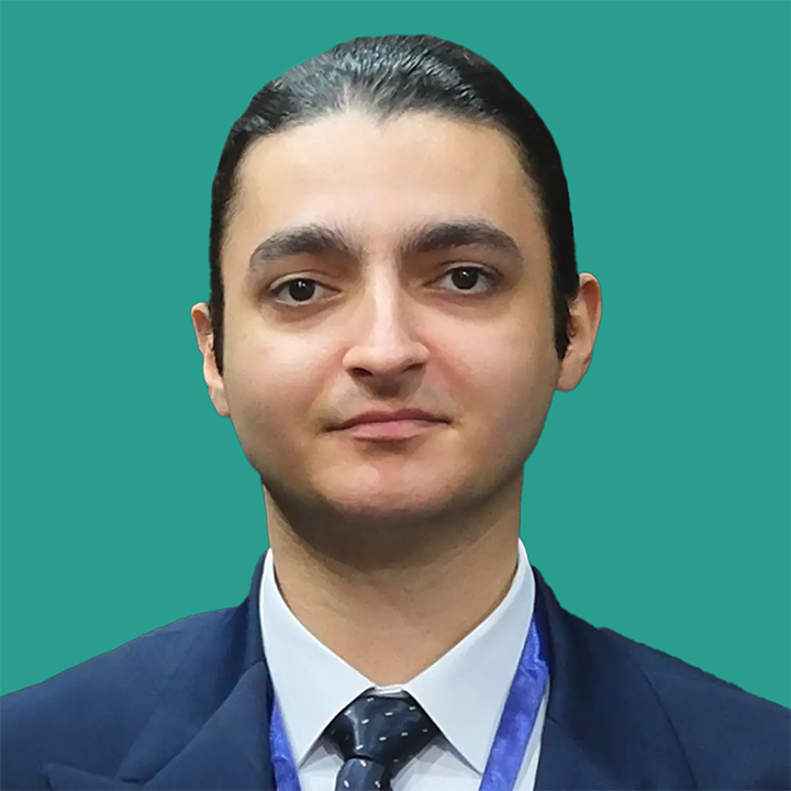 Mahdiyar Baladzadeh Photo in a dark blue suit and tie with a teal green background